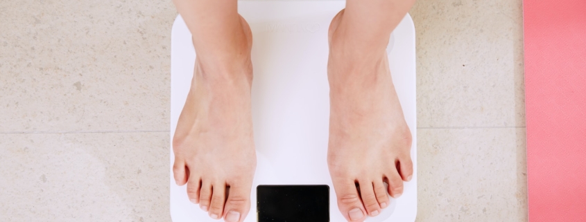 person standing on white digital bathroom scale