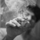 grayscale photo of person holding cigarette stick