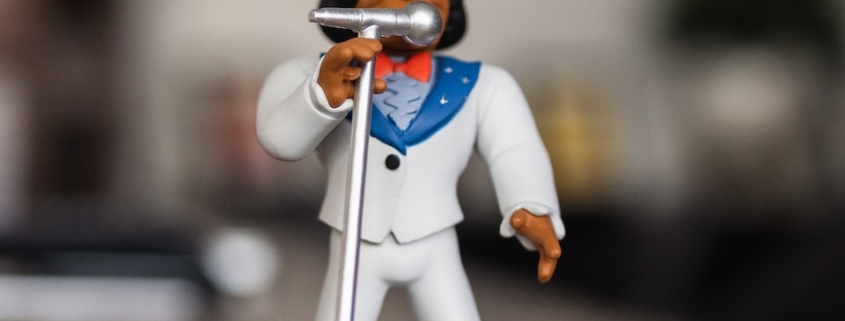 man singing figurine on selective focus photography