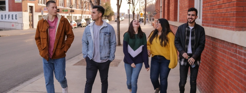 three men and laughing two women walking side by side