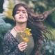 woman holding green plant in shallow focus photography