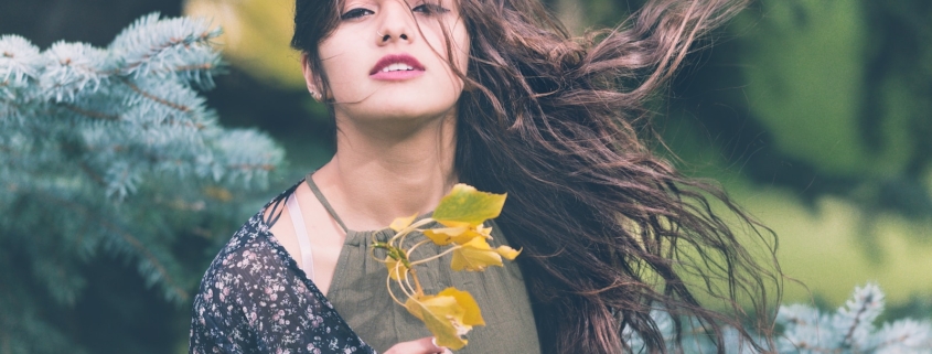 woman holding green plant in shallow focus photography