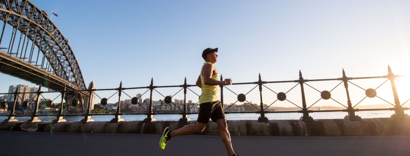 man in yellow tank top running near shore