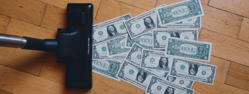 a pile of money sitting on top of a wooden floor