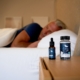 a man sleeping on a bed next to a bottle of cb