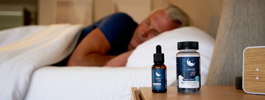 a man sleeping on a bed next to a bottle of cb