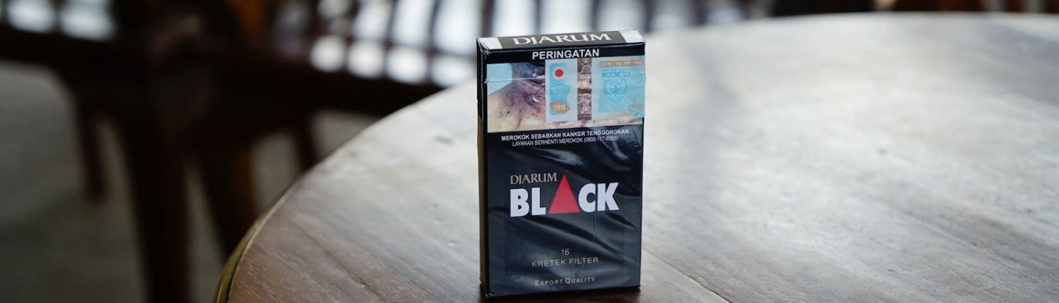 Black cigarette box on top of brown wooden table