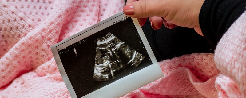 a person is holding a picture of a baby